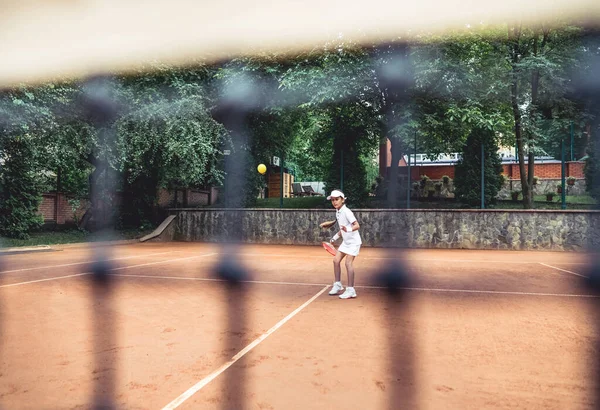 オープンテニスコートでスポーティな女の子の完全長撮影 スポーツクラブでテニスをしている子供の女の子の選手 子供のためのアクティブな運動 — ストック写真