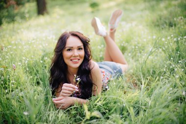 güneşli yaz gün, güzel bir genç kadın çim üzerinde yalan