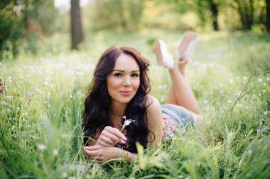 güneşli yaz gün, güzel bir genç kadın çim üzerinde yalan