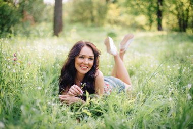 güneşli yaz gün, güzel bir genç kadın çim üzerinde yalan