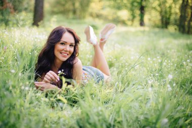 güneşli yaz gün, güzel bir genç kadın çim üzerinde yalan