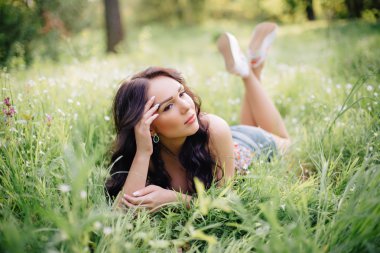 güneşli yaz gün, güzel bir genç kadın çim üzerinde yalan