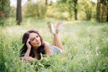 güneşli yaz gün, güzel bir genç kadın çim üzerinde yalan