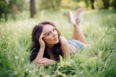 güneşli yaz gün, güzel bir genç kadın çim üzerinde yalan