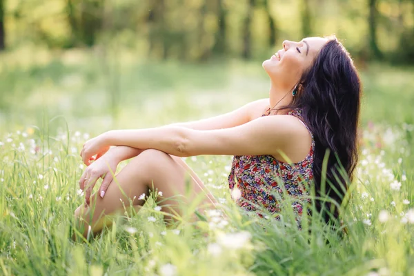 güneşli yaz gün, güzel bir genç kadın çim üzerinde yalan