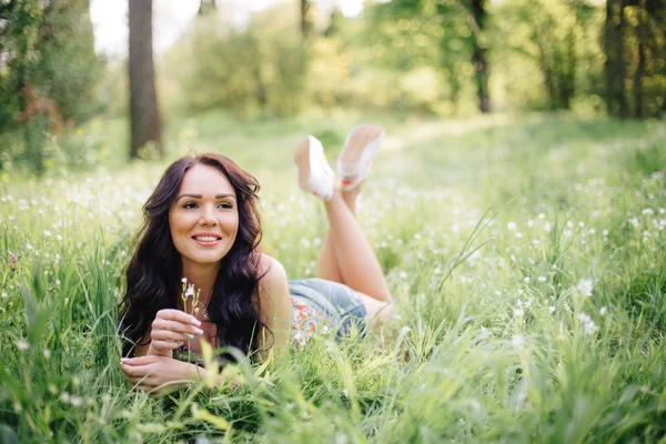 güneşli yaz gün, güzel bir genç kadın çim üzerinde yalan