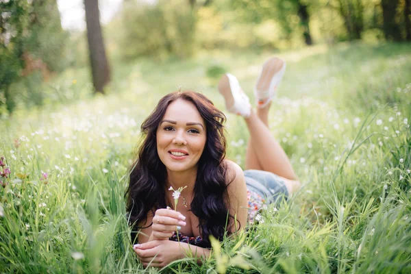 güneşli yaz gün, güzel bir genç kadın çim üzerinde yalan