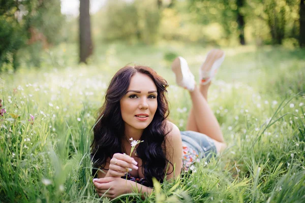 güneşli yaz gün, güzel bir genç kadın çim üzerinde yalan