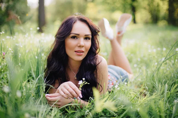 güneşli yaz gün, güzel bir genç kadın çim üzerinde yalan