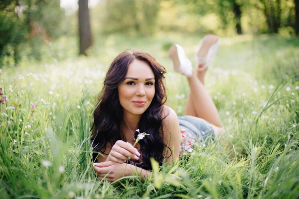 güneşli yaz gün, güzel bir genç kadın çim üzerinde yalan