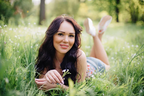 güneşli yaz gün, güzel bir genç kadın çim üzerinde yalan