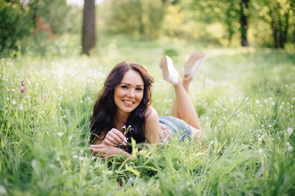 güneşli yaz gün, güzel bir genç kadın çim üzerinde yalan