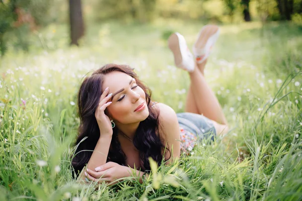 güneşli yaz gün, güzel bir genç kadın çim üzerinde yalan