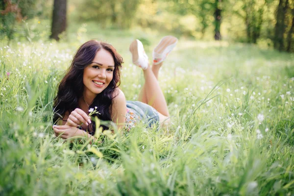 güneşli yaz gün, güzel bir genç kadın çim üzerinde yalan