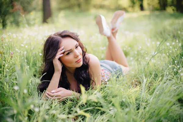 güneşli yaz gün, güzel bir genç kadın çim üzerinde yalan