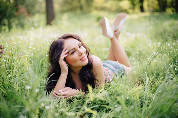 güneşli yaz gün, güzel bir genç kadın çim üzerinde yalan