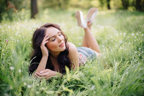 güneşli yaz gün, güzel bir genç kadın çim üzerinde yalan
