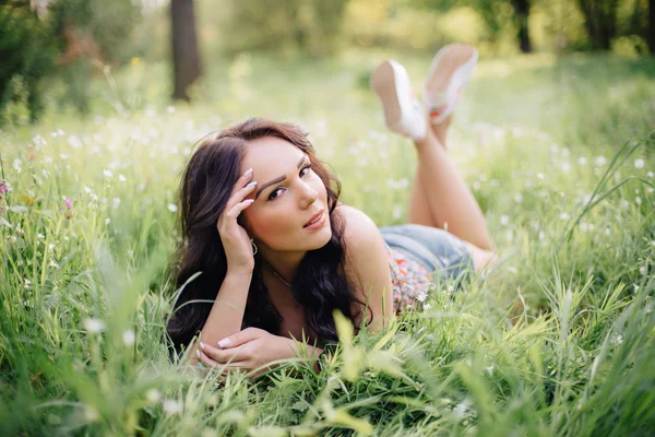 güneşli yaz gün, güzel bir genç kadın çim üzerinde yalan