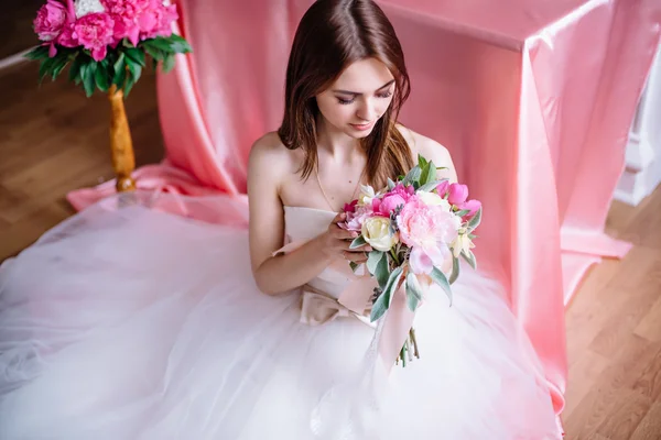 Joven hermosa novia con un ramo de peonía rosa — Foto de Stock