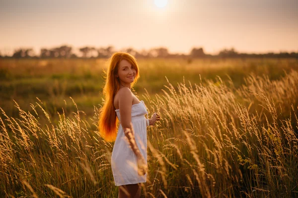 夕暮れ時のフィールドで美しい赤毛の少女 — ストック写真