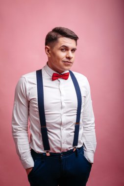 Genç neşeli şık giyimli adam kuşkuyla izlemekte