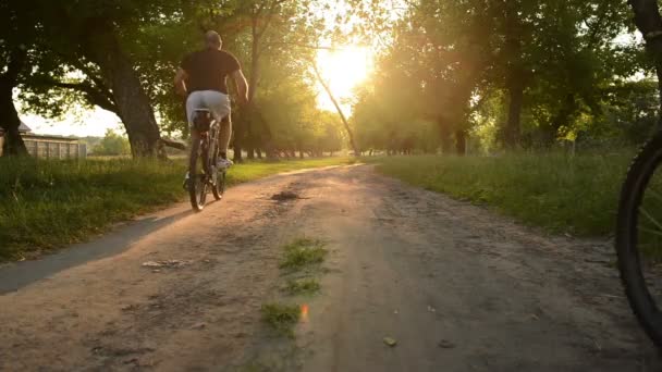 Två cyklister ridning på en grusväg — Stockvideo