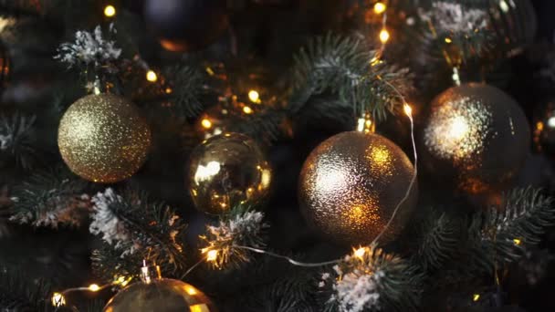Kerstboom versierd met decoratieve ballen en verlichting op een donkere achtergrond — Stockvideo