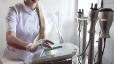 Güzellik uzmanı RF kaldırma aparatını ayarlıyor.