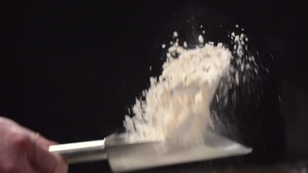 Scattering flour on a black background. — Stock Video