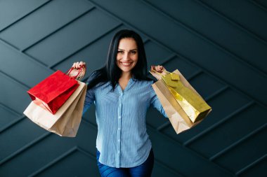 Alışveriş torbalarını elinde tutan mutlu kadın.