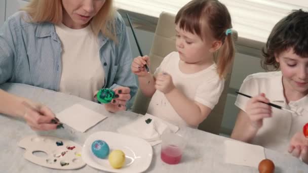 Rodzina maluje wielkanocne jaja.. — Wideo stockowe