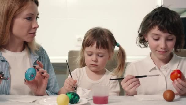 A família está pintando ovos de Páscoa. — Vídeo de Stock