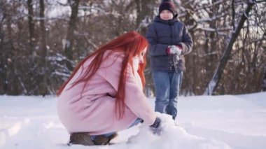 Anne ve oğlu kartopu oynuyorlar..