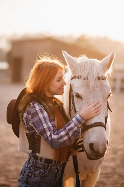 Une femme caressant un cheval dans un ranch. — Photo