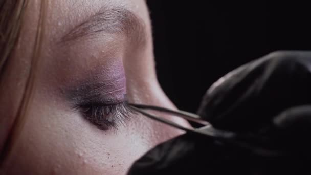 Make-up kunstenaar breidt wimpers uit. — Stockvideo