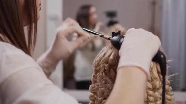 O cabeleireiro faz afro-cachos ao cliente. — Vídeo de Stock
