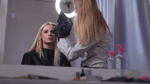 Makeup artist gör makeup till en kund. — Stockvideo