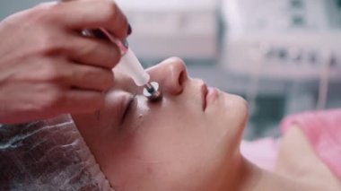 Kozmetik uzmanı mikro akım terapisi yapıyor. Kapat..