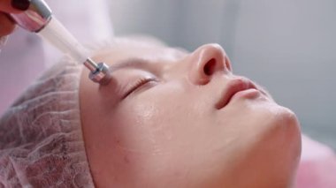 Kozmetik uzmanı mikro akım terapisi yapıyor. Kapat..