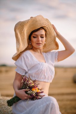 Güzel bir kadın biçilmiş tarlada.