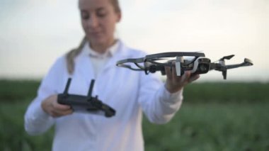 Kadın tarım uzmanı dronu ayarlıyor.