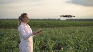 Kadın tarım uzmanı dronu kontrol ediyor.