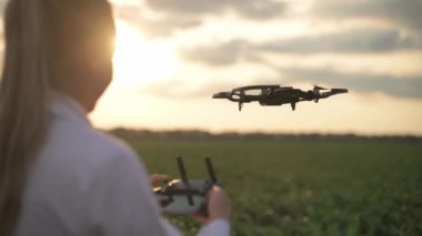 Kadın tarım uzmanı dronu kontrol ediyor.