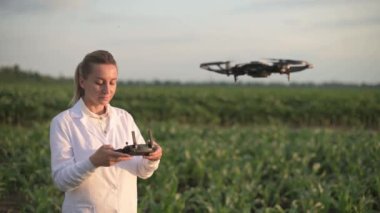Kadın tarım uzmanı dronu kontrol ediyor.