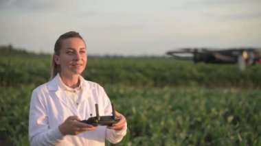 Kadın tarım uzmanı dronu kontrol ediyor.