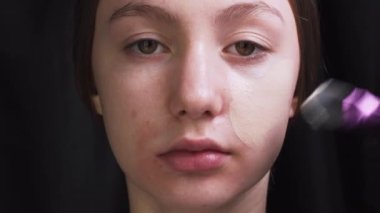 Makyaj sanatçısı müşteriye makyaj yapıyor.