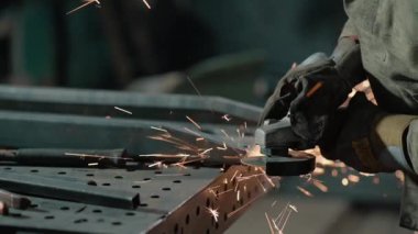 Heavy Industry Engineering Factory Interior ile Endüstriyel İşçi Angle Grinder ve Metal Parça Kesimi. Güvenlik Üniforması ve Sert Şapka Üretim Metal Yapıları Müteahhiti.