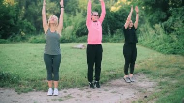 Parkta spor yapan üç orta yaşlı kız arkadaş. Ön görünüm.