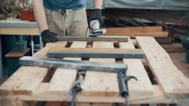 Bir işçi, çelik bir parçanın pasını öğütücüyle öğütüyor. Yakın plan..