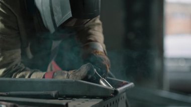 Mig kaynaklarıyla çelik kaynaklama. Ellerinizi yakın tutun. Yavaş çekim.